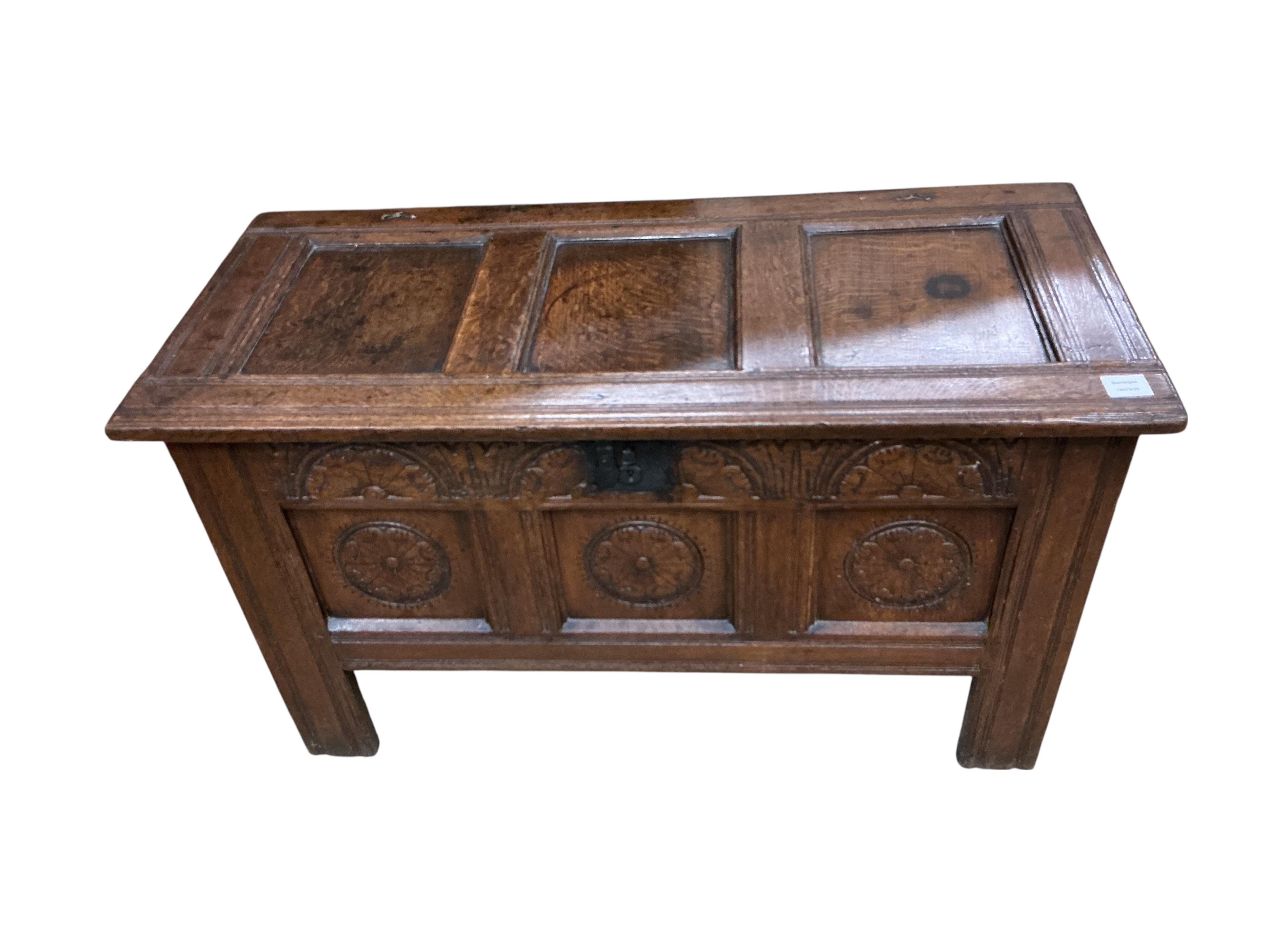An oak coffer with three panels carved with roundels, width 106cm, depth 47cm, height 61cm